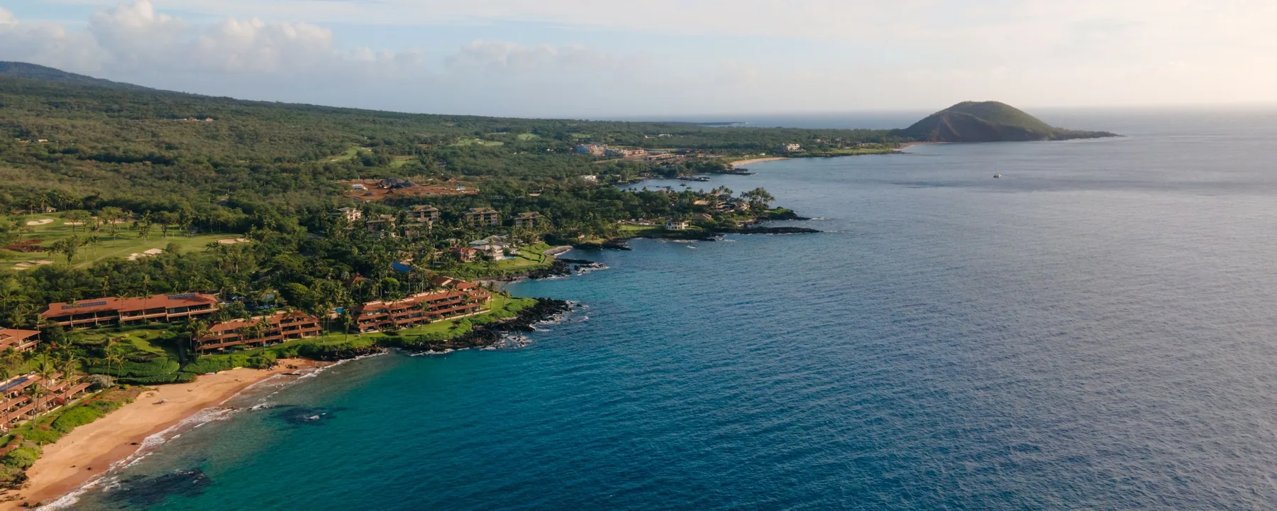 Aerial view of the green Wailea and Makena coastline of Maui with rocky points and clear blue water